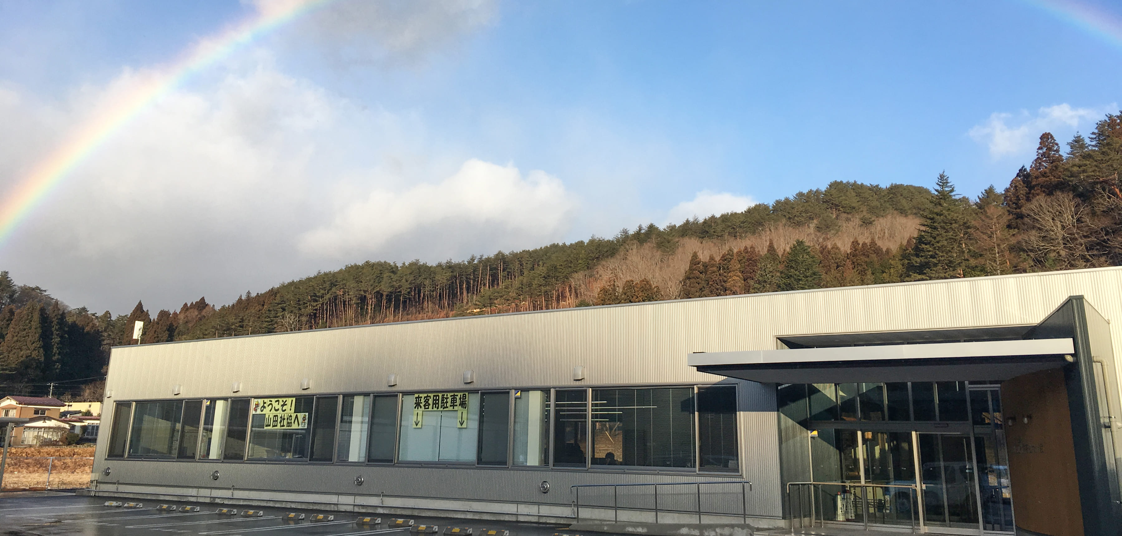 山間の外観と青空にかかる美しい虹